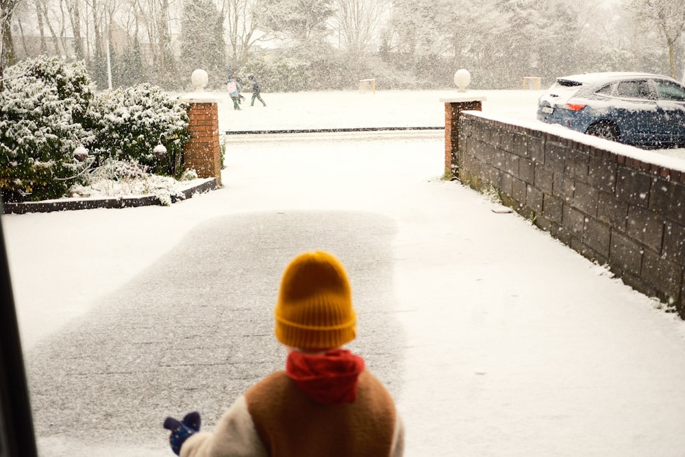 a person looking out a window in the snow