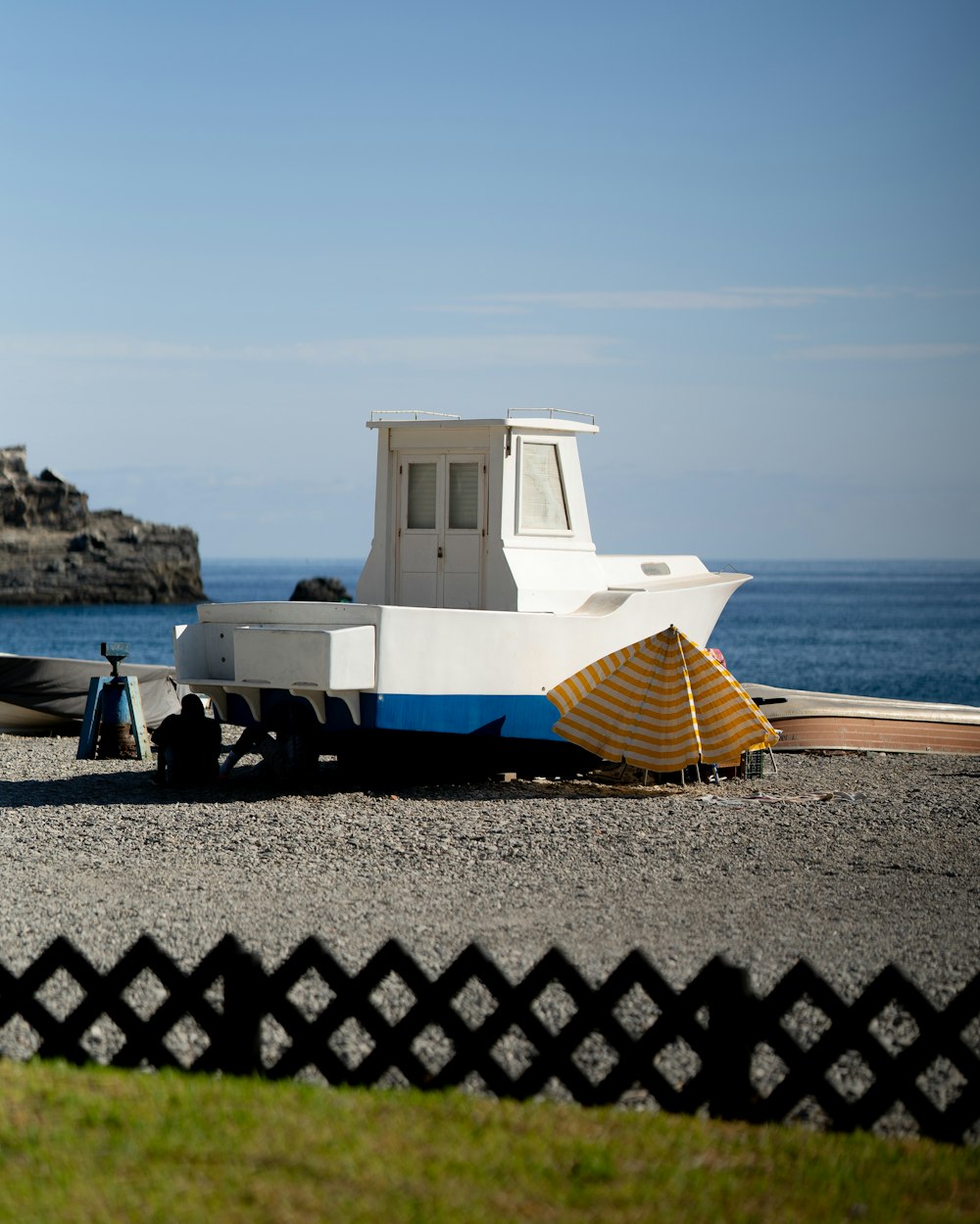 a boat sitting on top of a beach next to the ocean