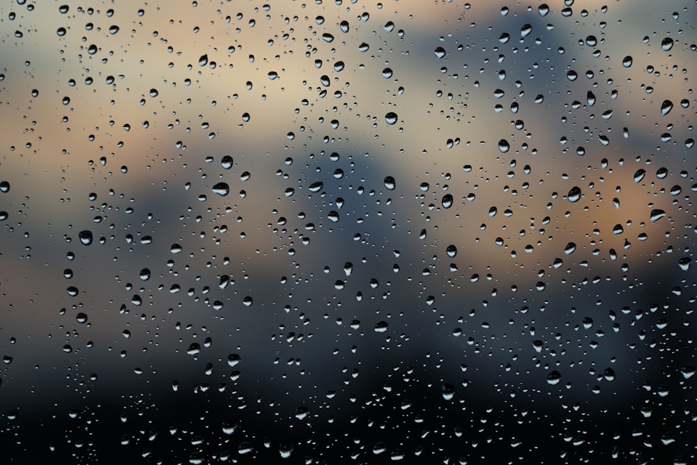 rain drops on a window with a city in the background