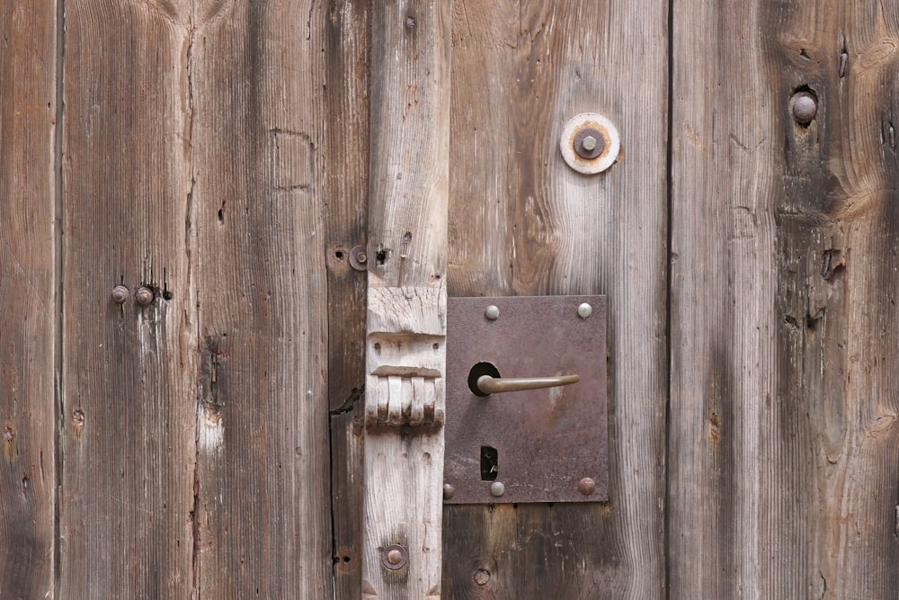 a close up of a door handle on a wooden door