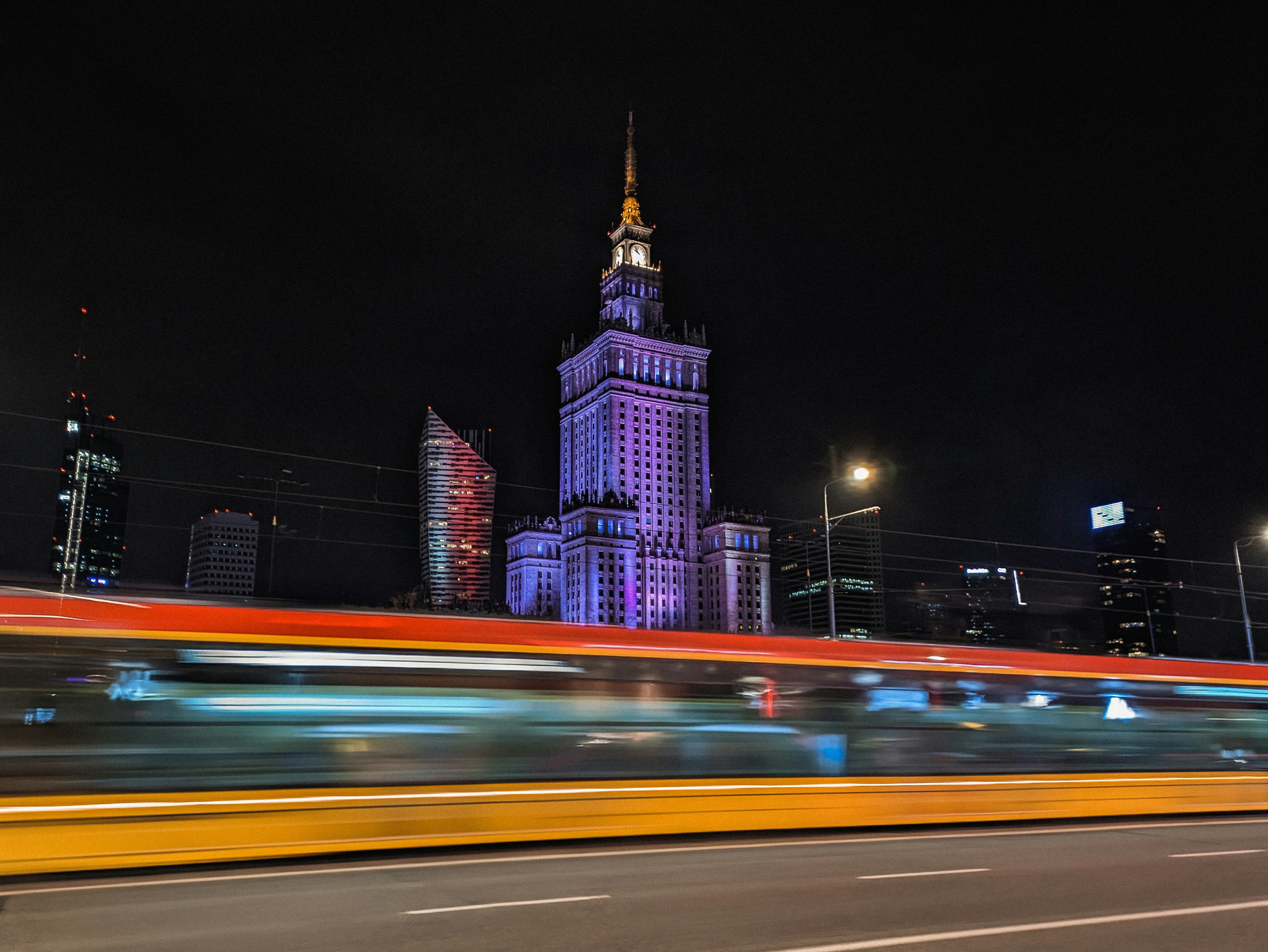 ein großer Uhrenturm, der nachts über einer Stadt thront