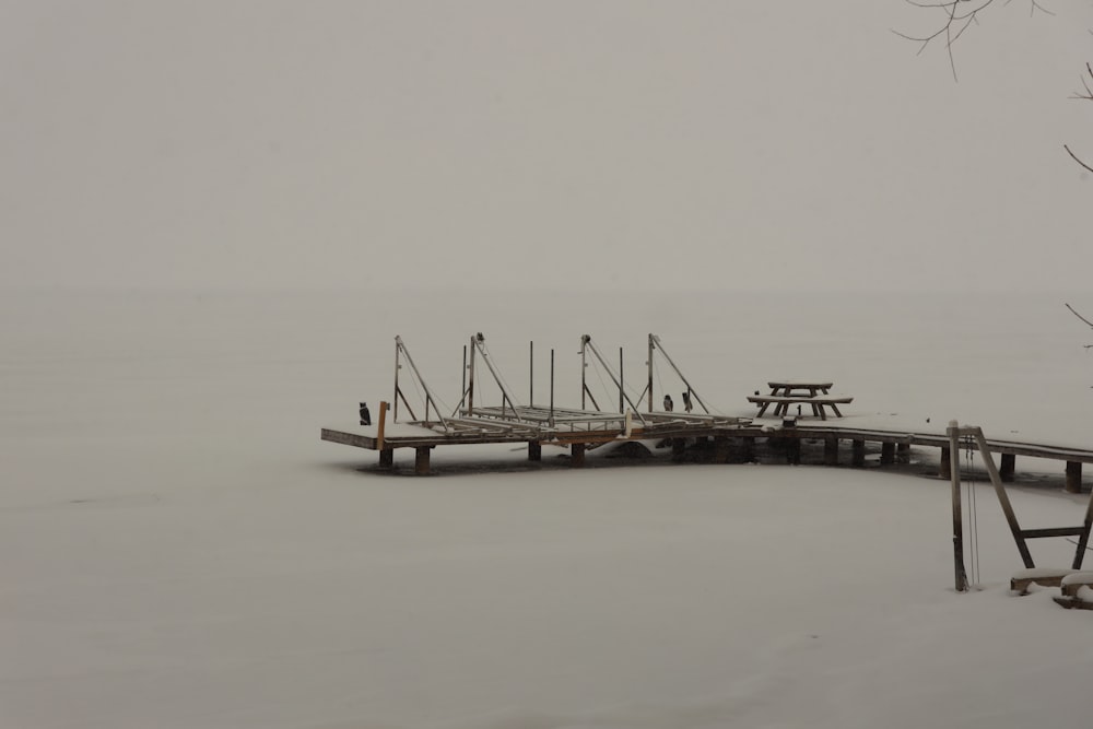 a dock in the middle of a snow covered field