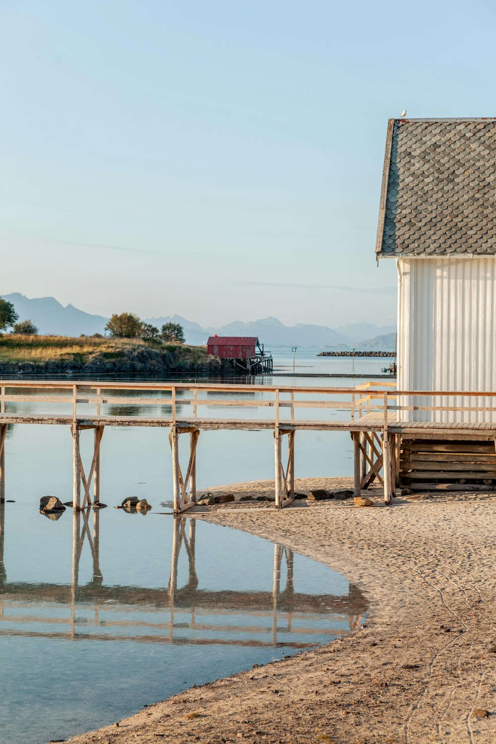 a small white building sitting next to a body of water