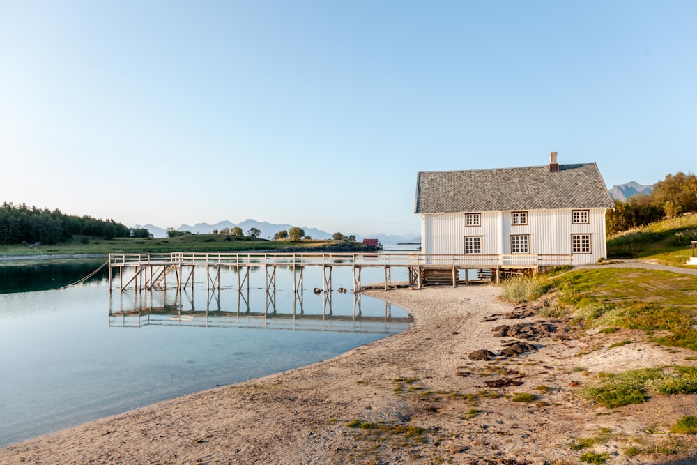 ein Haus, das an einem Strand neben einem Gewässer liegt