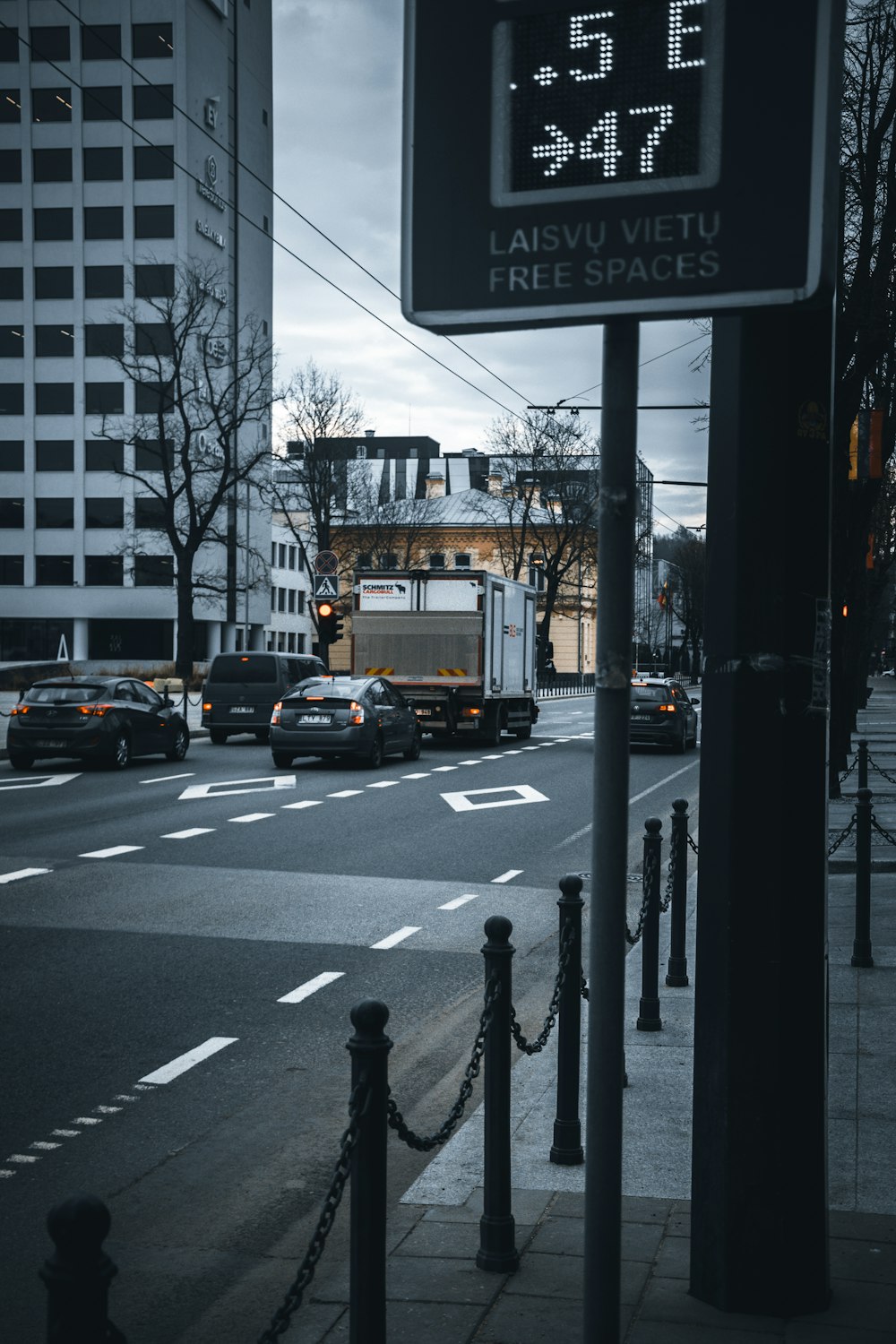 a city street filled with traffic next to tall buildings