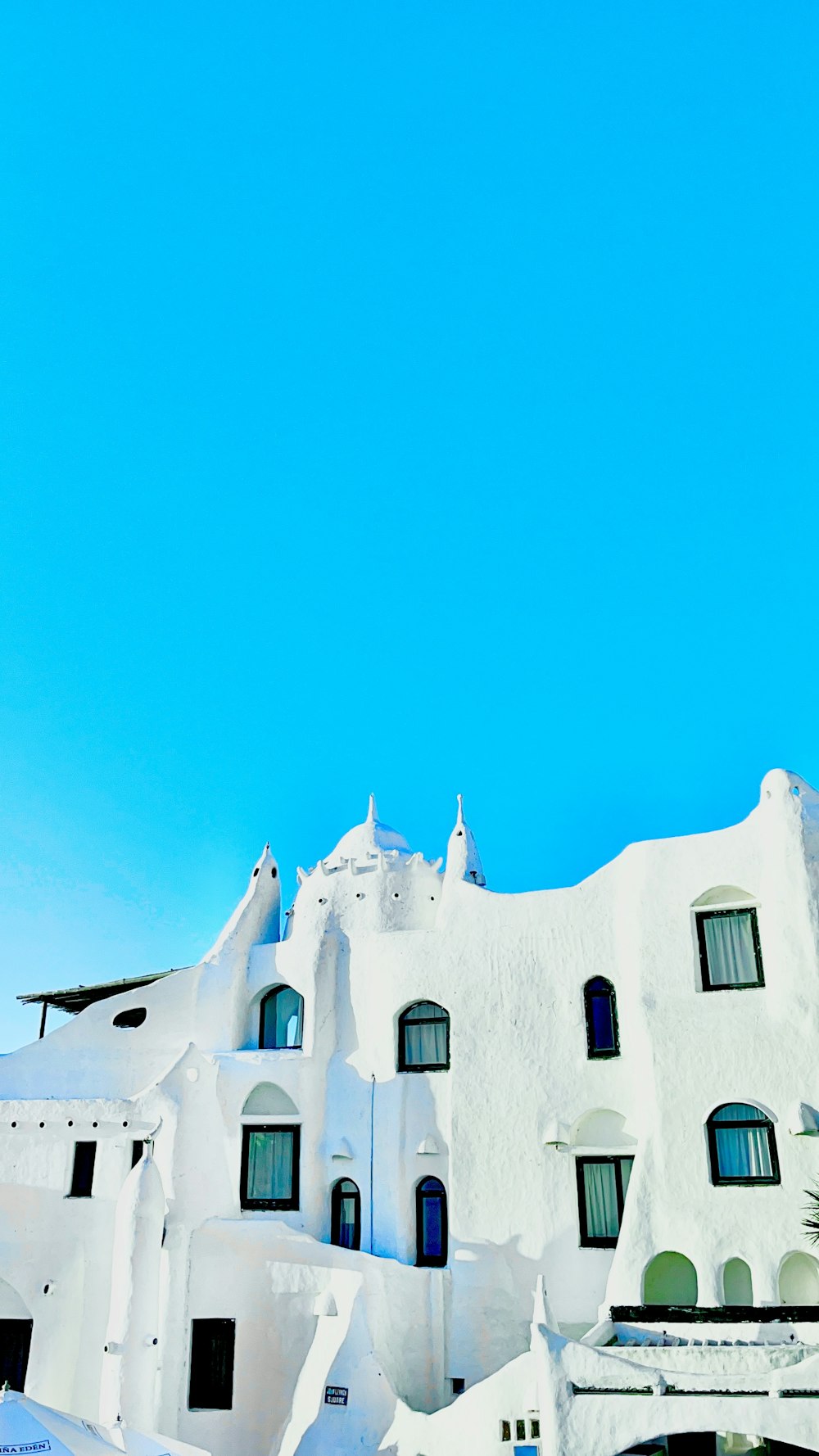 a very tall white building with a clock on it's side