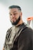a man with a beard standing in front of a ladder