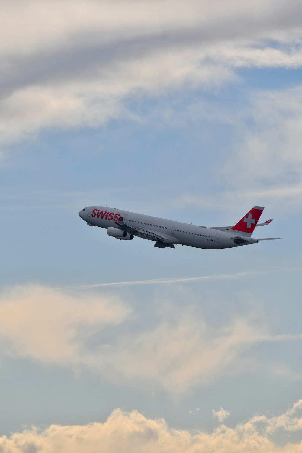 a large jetliner flying through a cloudy blue sky