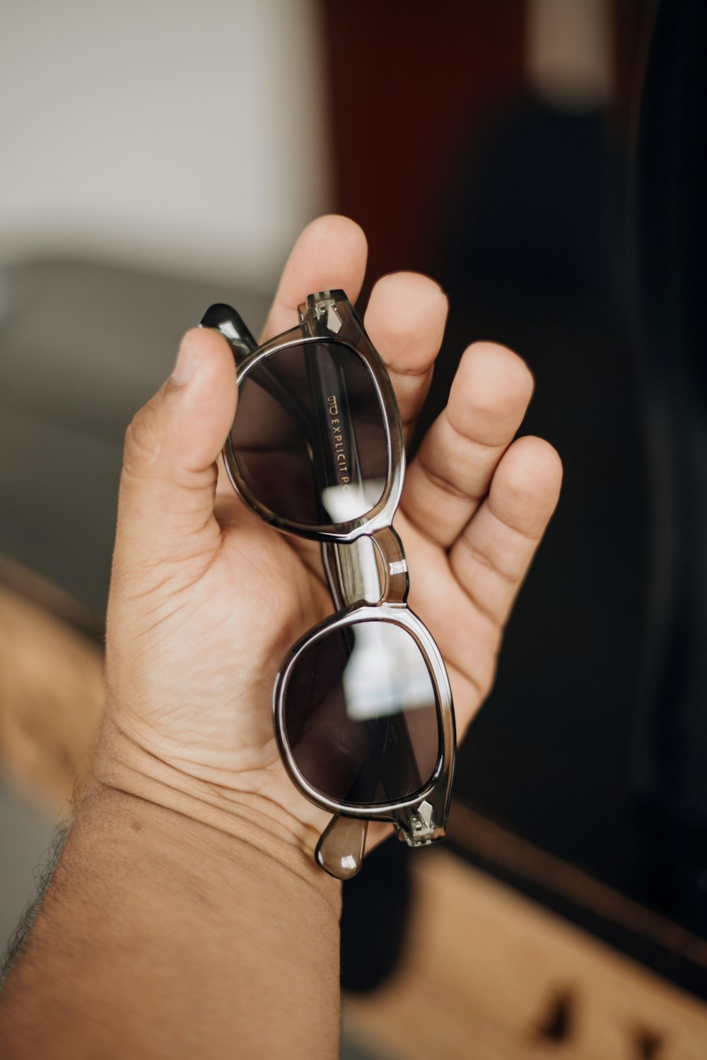 une personne tenant une paire de lunettes de soleil à la main