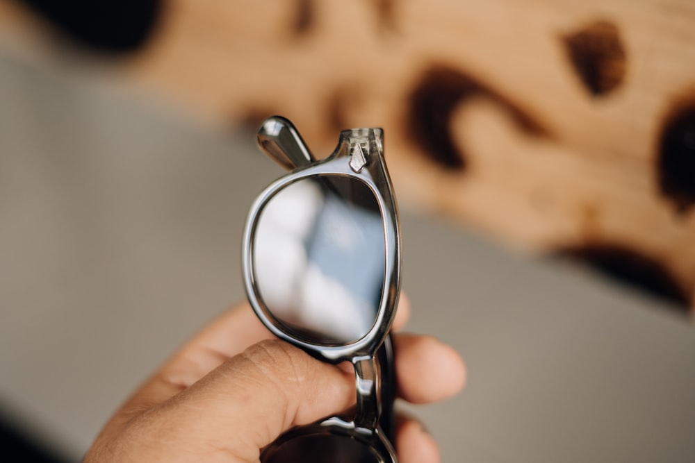 a person holding a pair of glasses in their hand