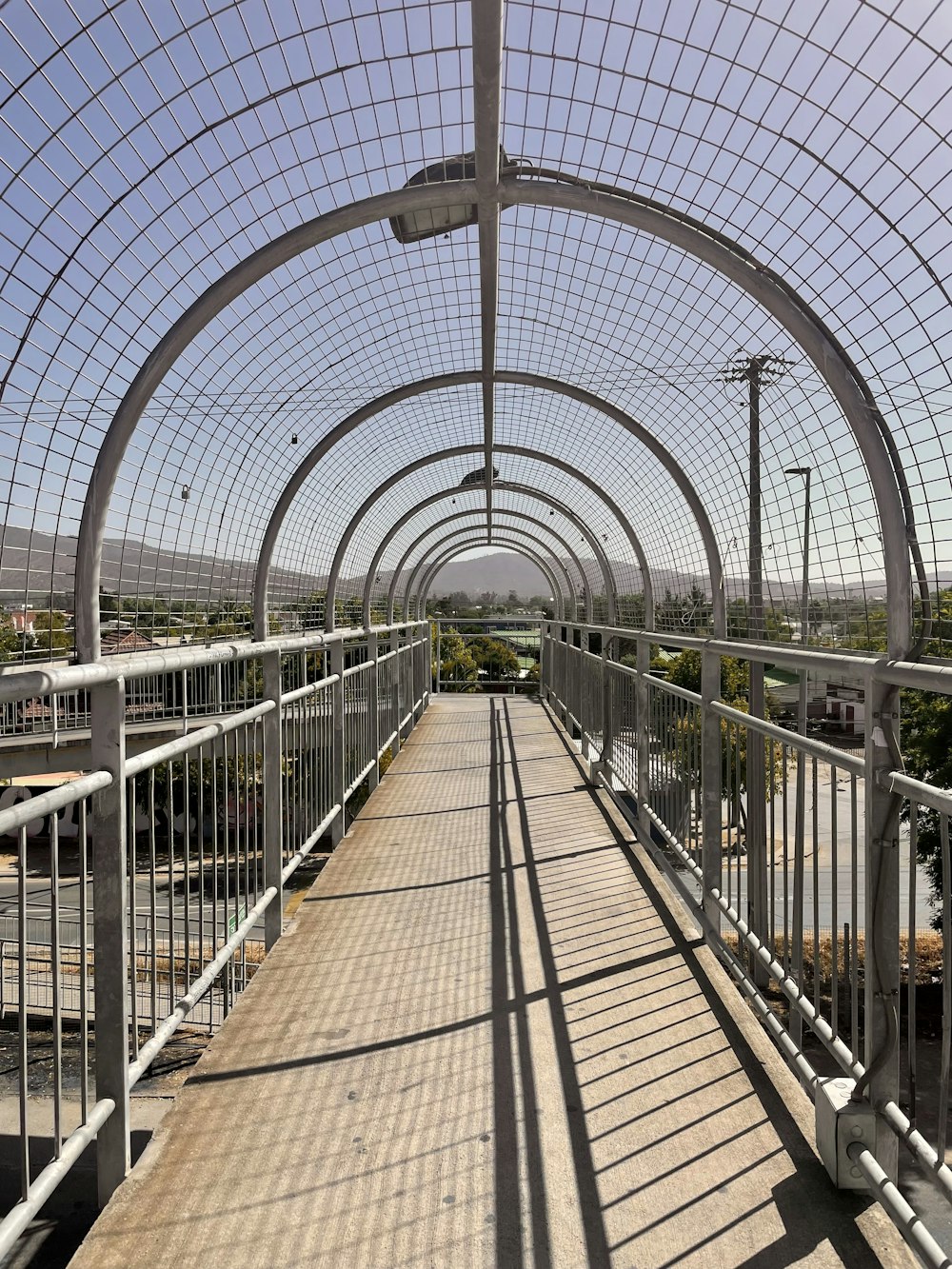 a walkway that has a metal fence on the side of it