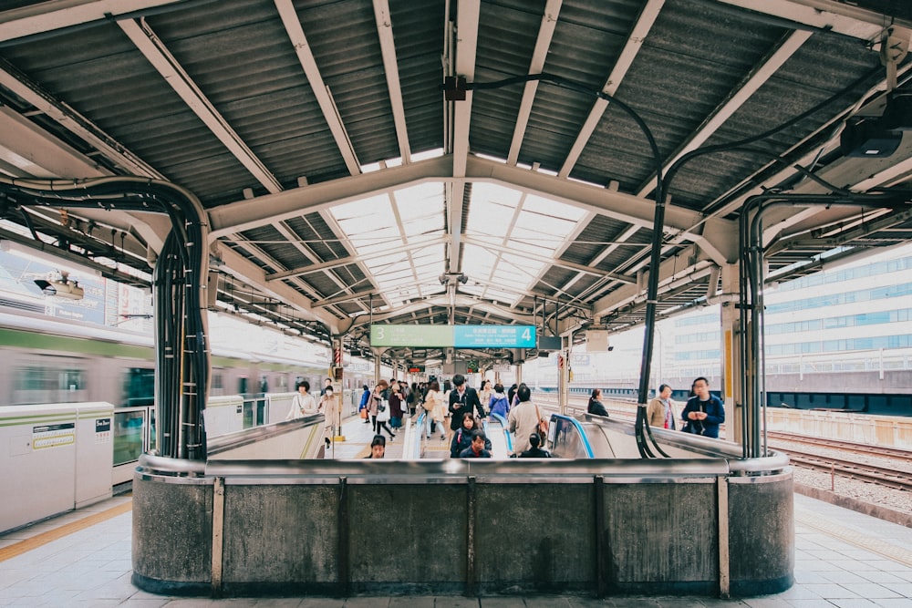 a group of people waiting for a train at a train station