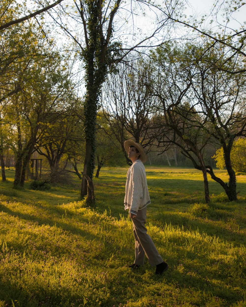 a man in a hat is walking through a field