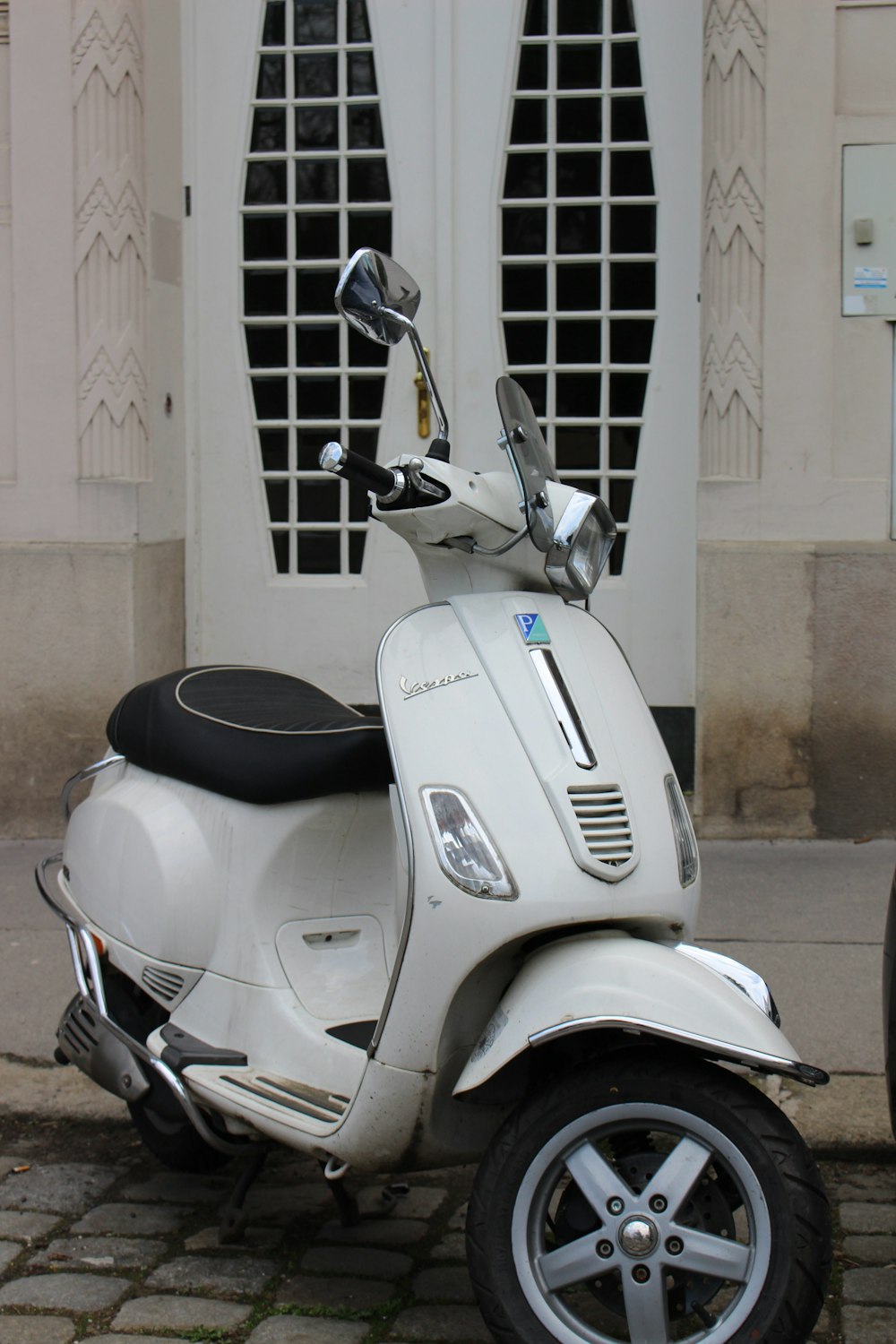 Un scooter blanco estacionado frente a un edificio