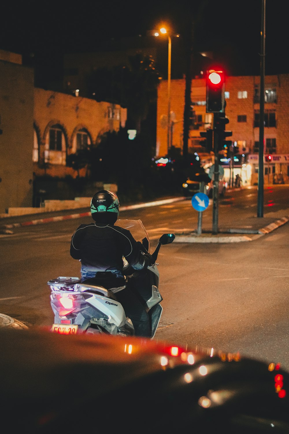 a man riding a motorcycle down a street at night