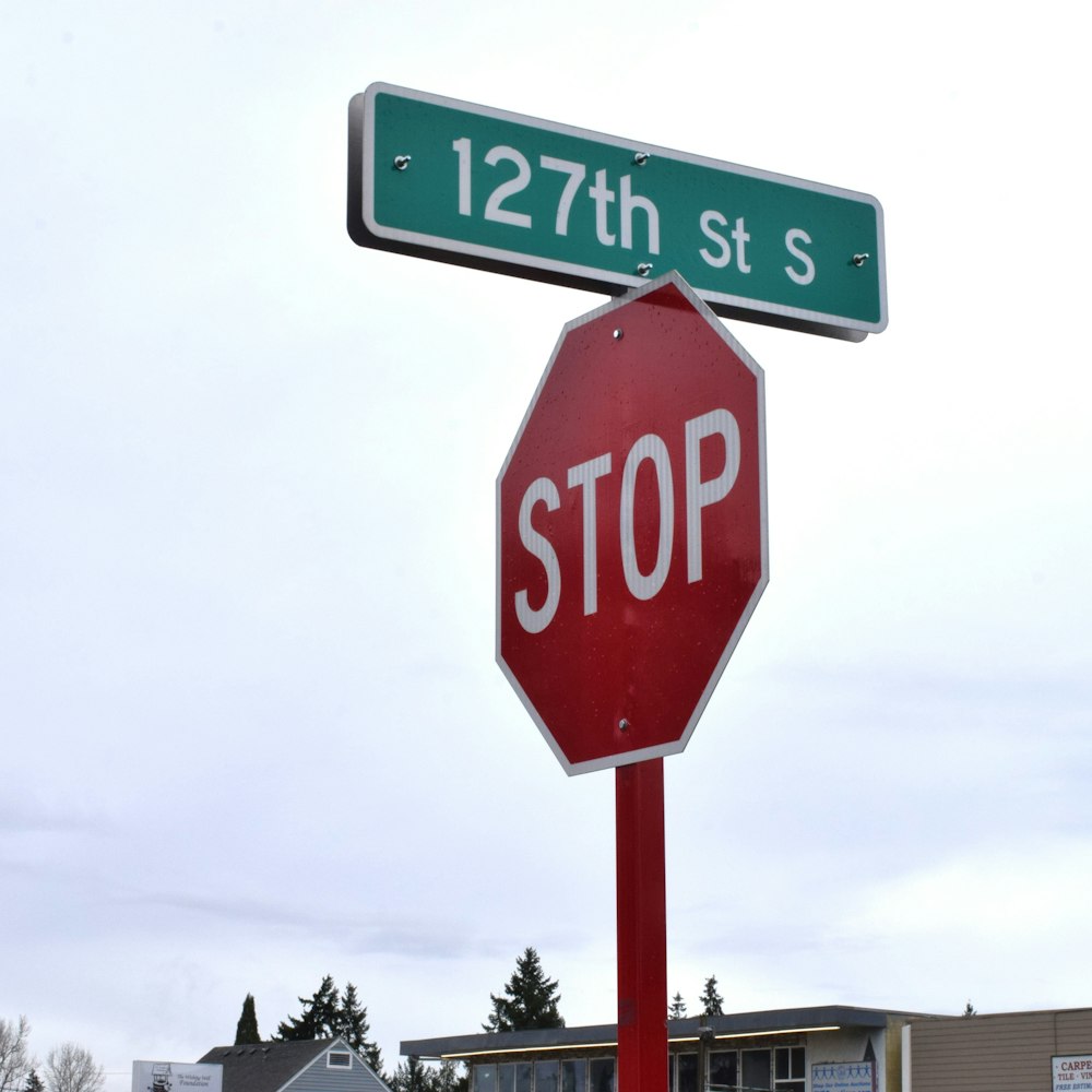 a red stop sign with a green street sign above it