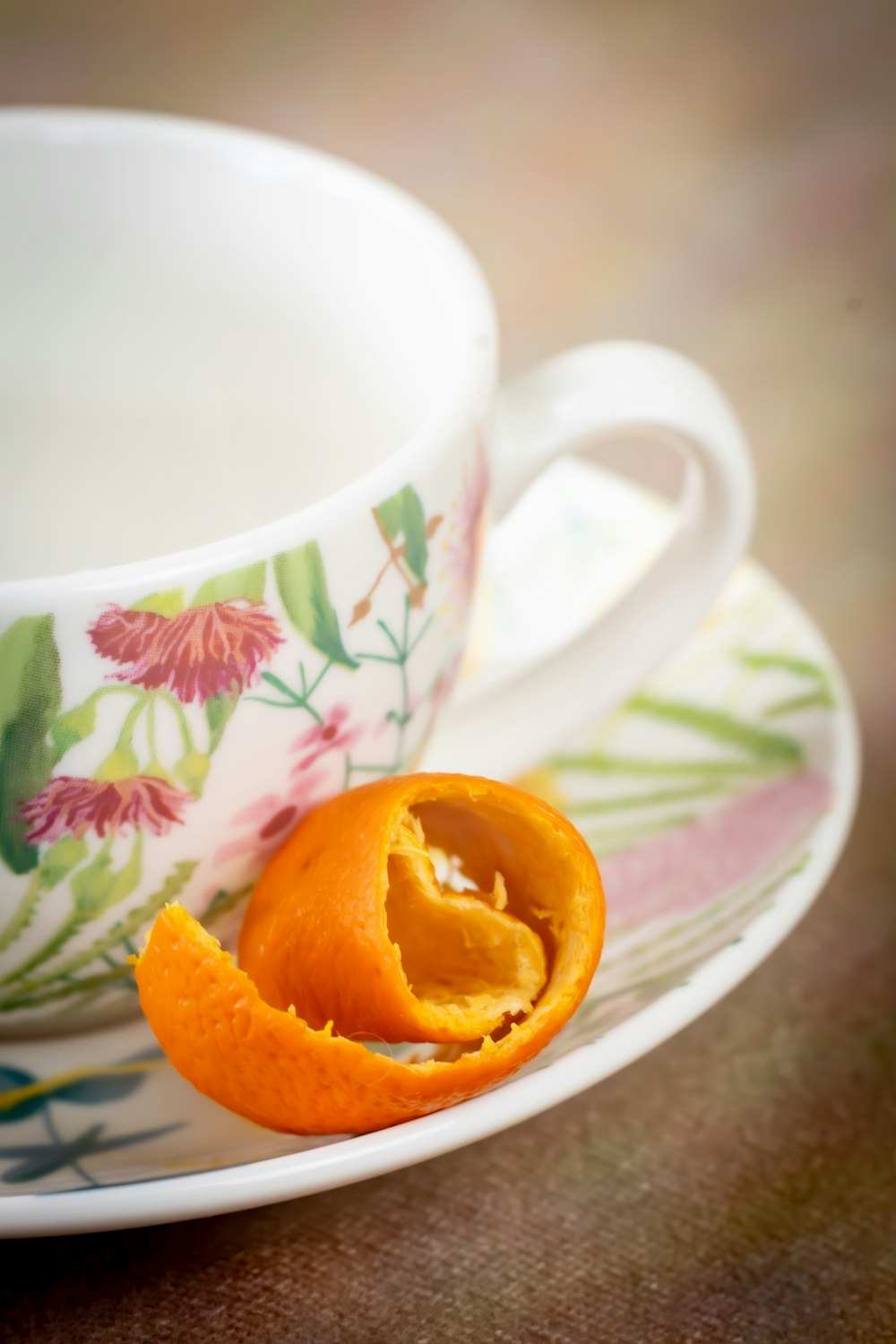 a peeled orange sitting on a plate next to a cup