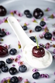 a spoon filled with yogurt and blueberries