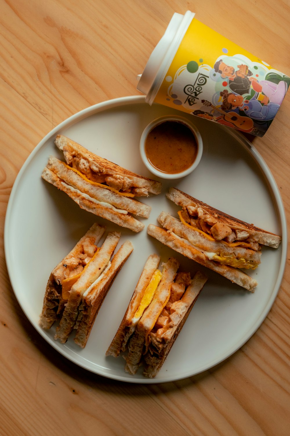 a white plate topped with sandwiches and a cup of coffee