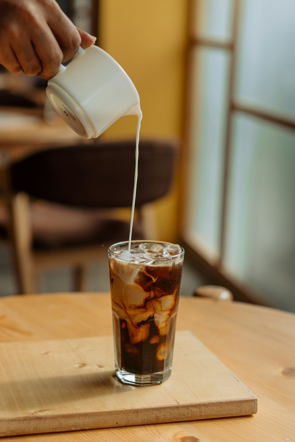 a person pours a beverage into a glass