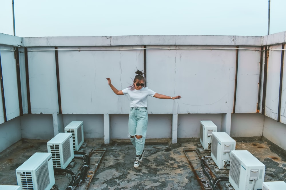 a person jumping in the air in front of some air conditioners