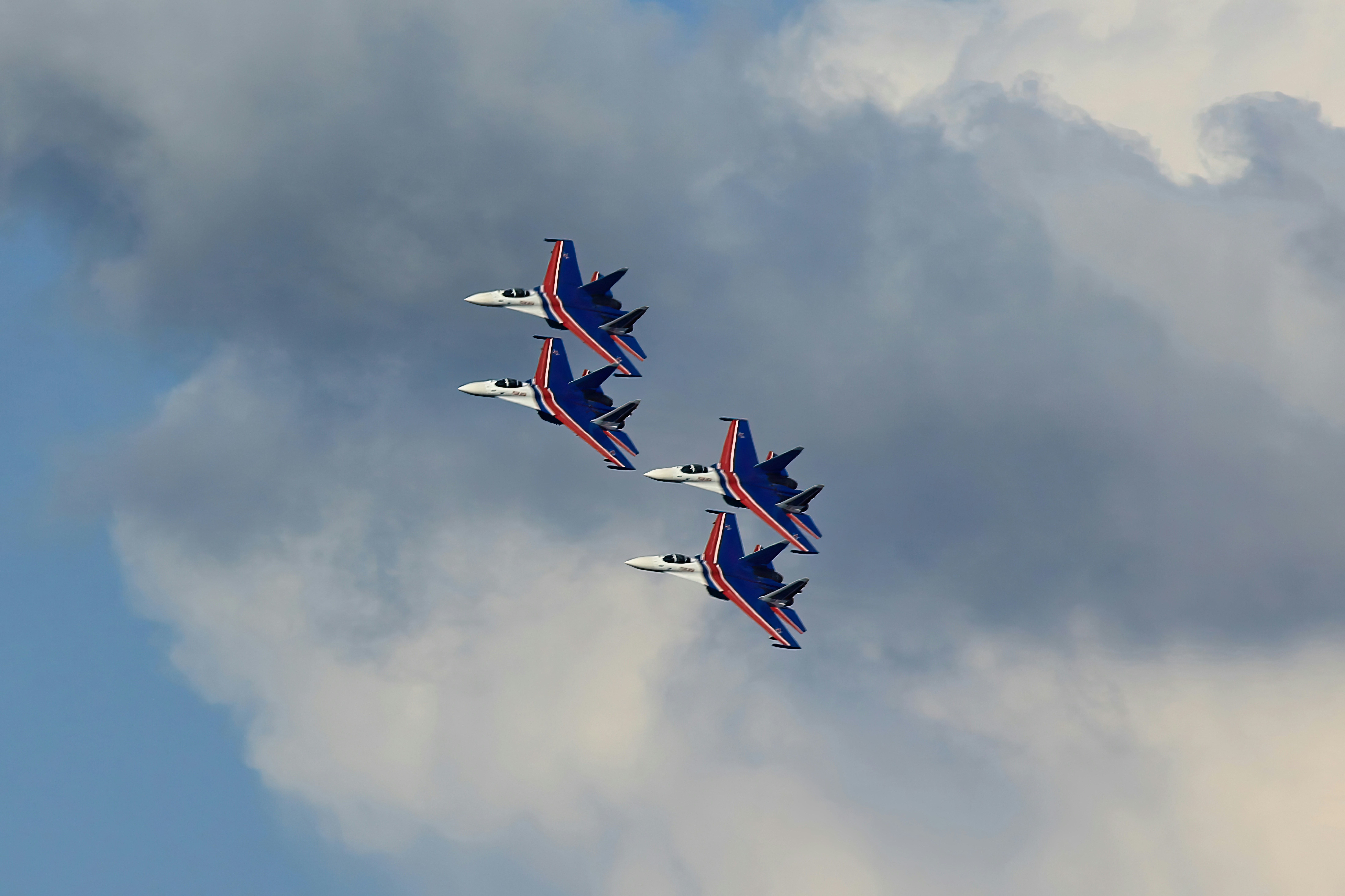 a group of jets flying through a cloudy sky
