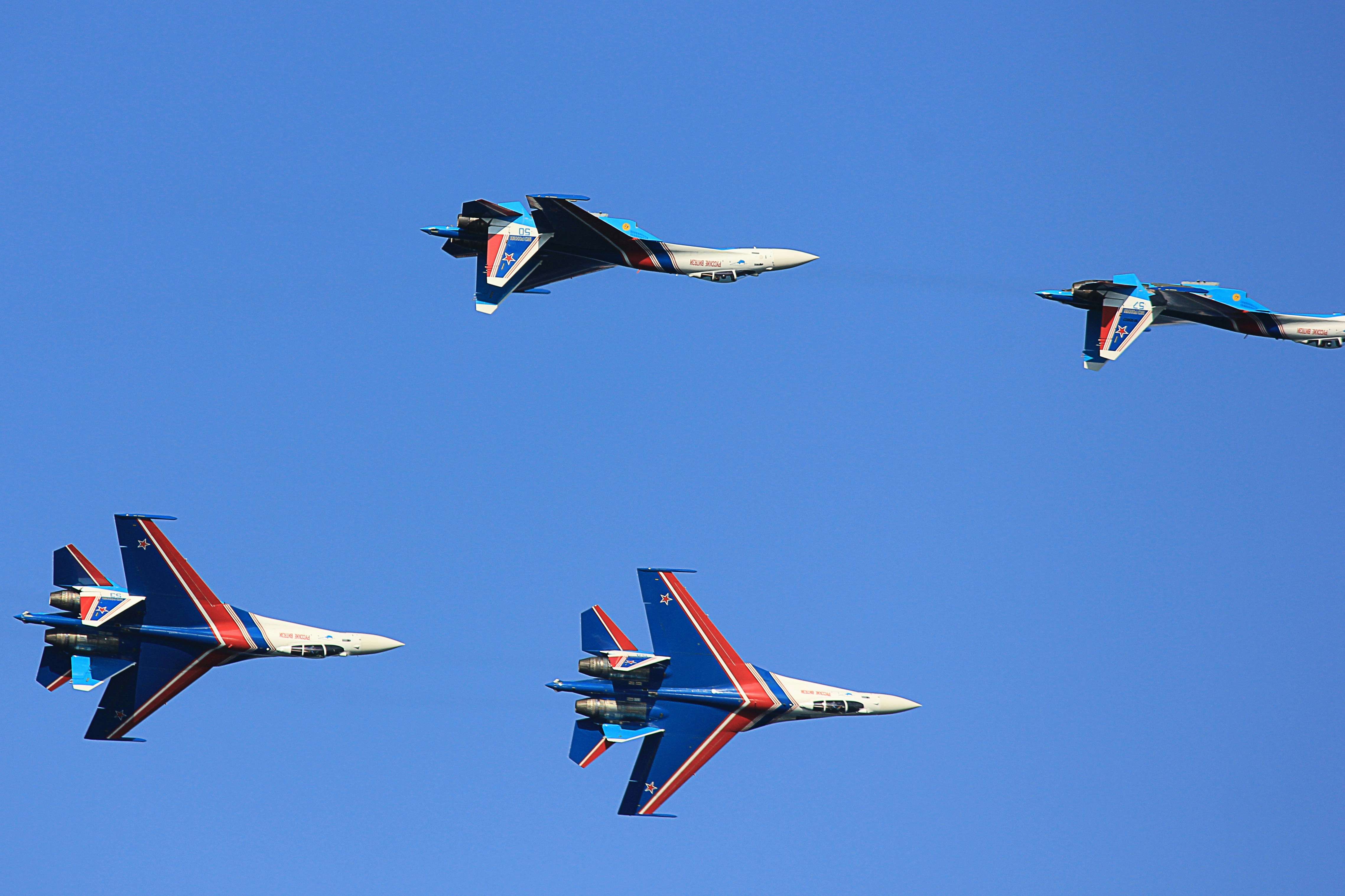 a group of fighter jets flying through a blue sky