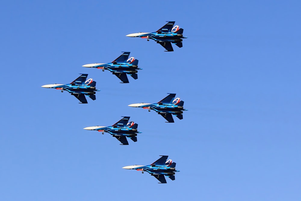 a formation of fighter jets flying through a blue sky