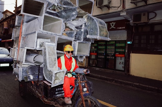 a man riding a bike with a large metal structure on it's back