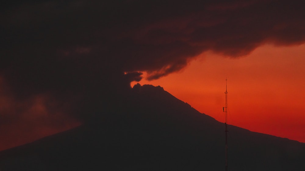 a very tall mountain under a cloudy sky