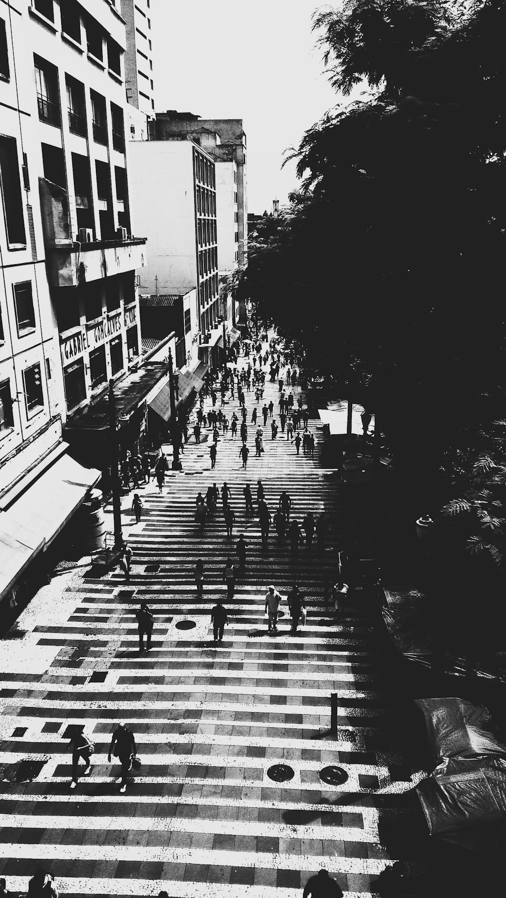 a black and white photo of people walking across a crosswalk