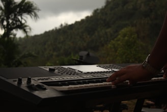 a person typing on a keyboard in front of a mountain