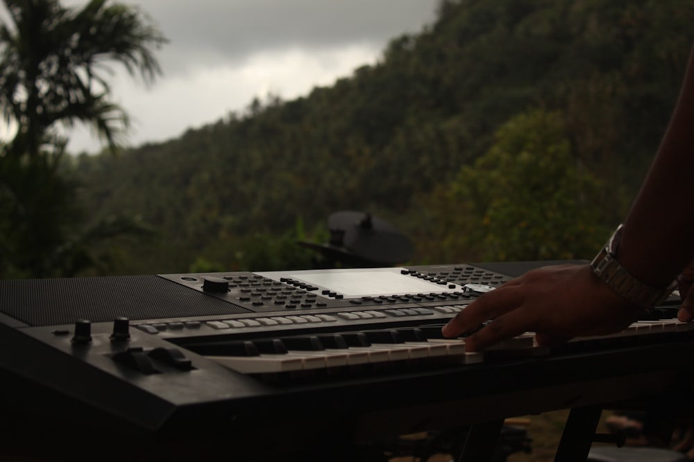 a person typing on a keyboard in front of a mountain