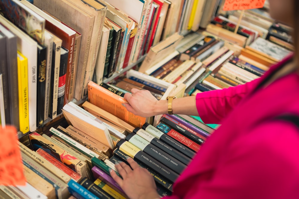 a woman selecting a book from a bookshelf