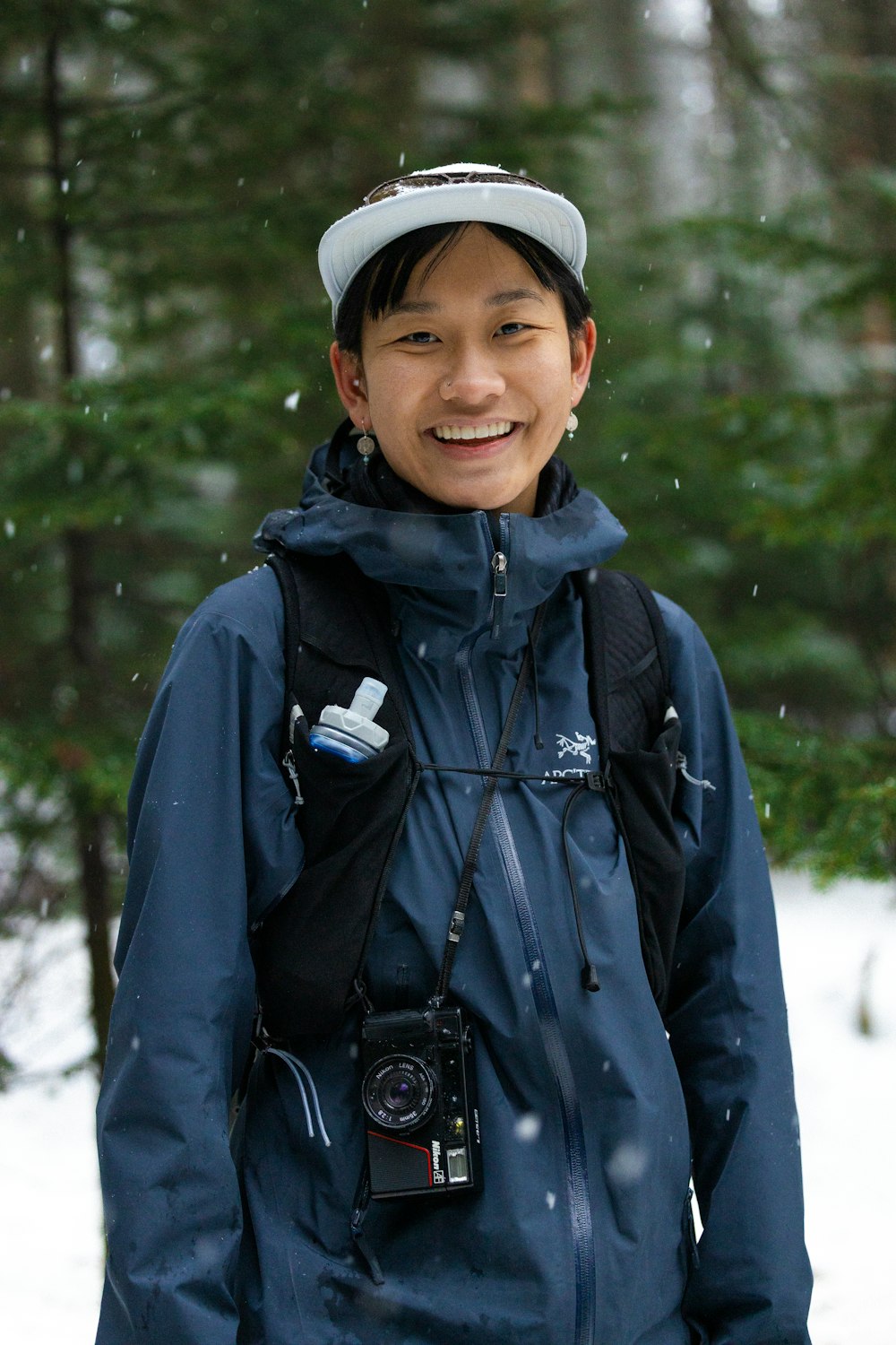 un uomo in piedi nella neve con una macchina fotografica