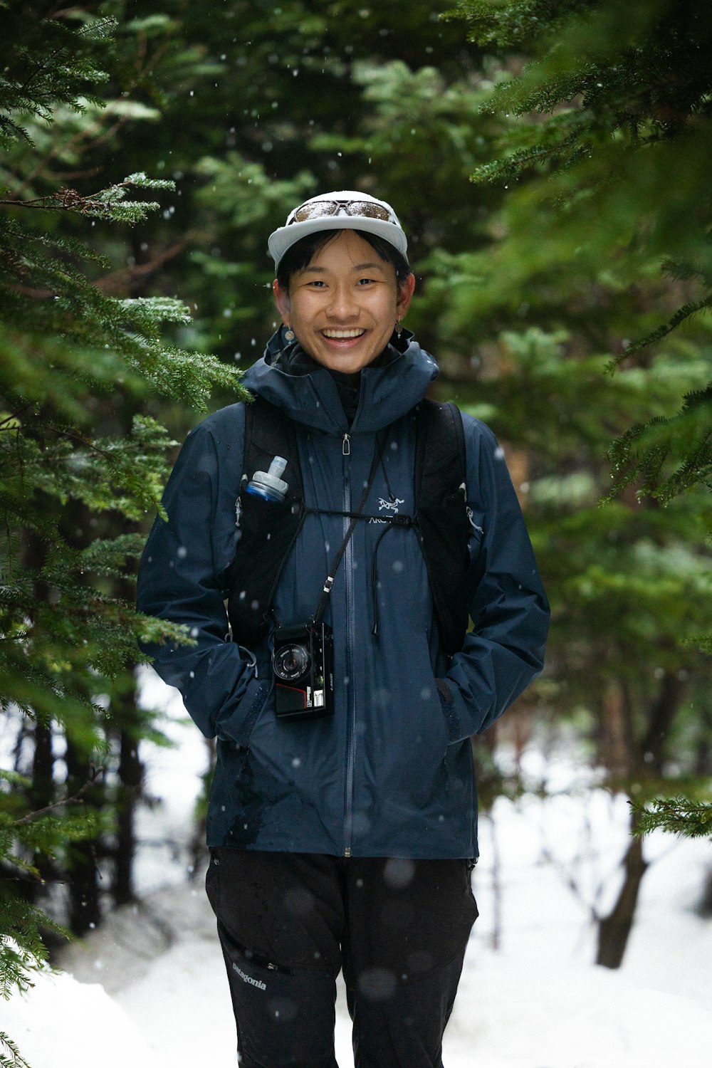 a person standing in the snow with a backpack