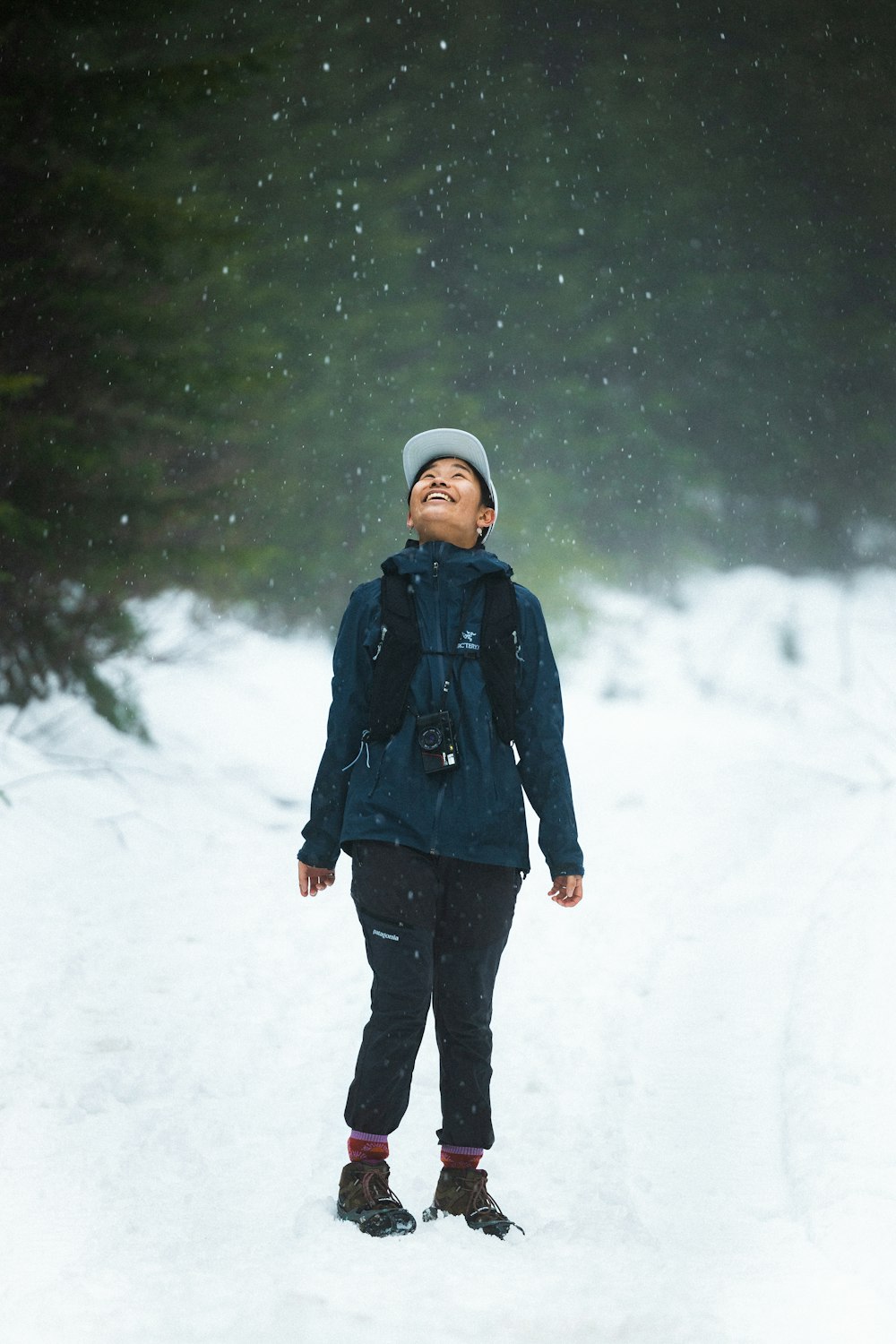 a person standing in the snow with their eyes closed