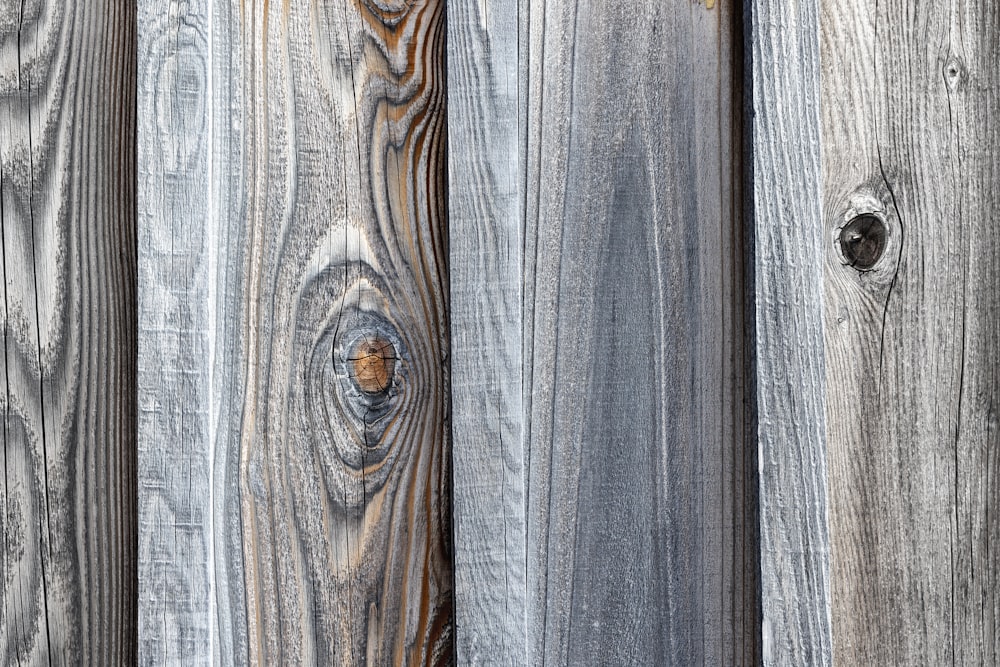 a close up of a wooden fence with holes in it