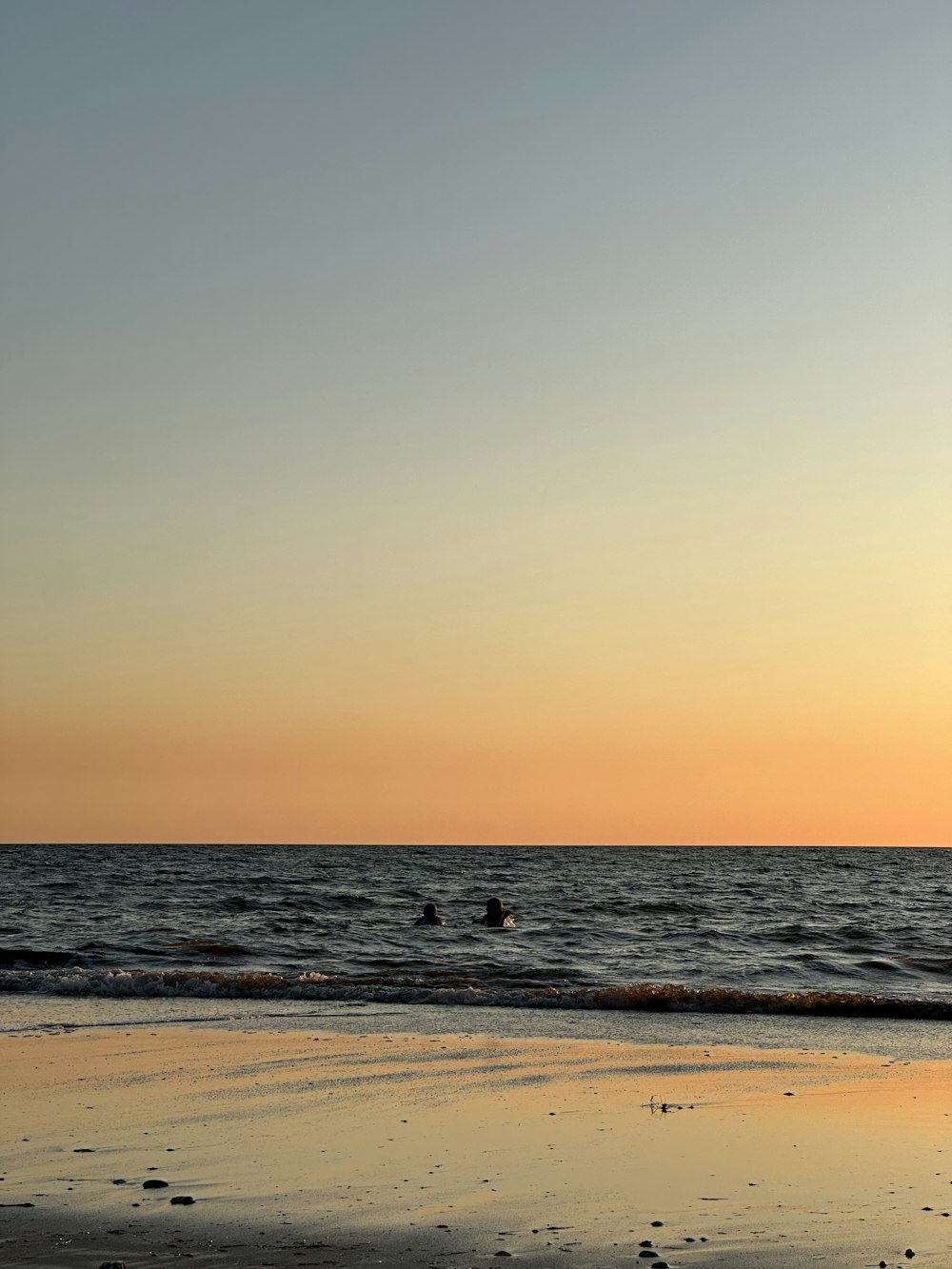 a person riding a surfboard on top of a sandy beach