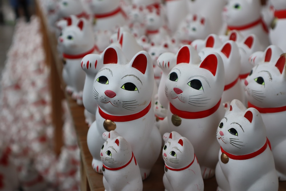 a group of white cat figurines sitting on top of a table