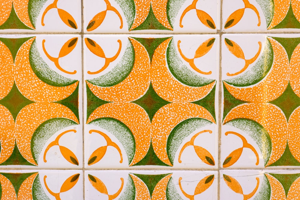 a close up of a tiled wall with orange and green designs