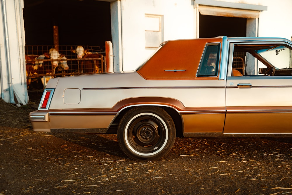 a brown and tan car parked in front of a building