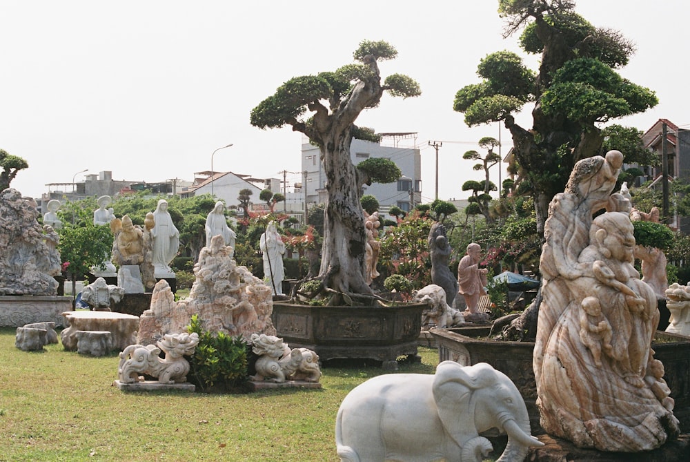 a group of statues of people and animals in a park