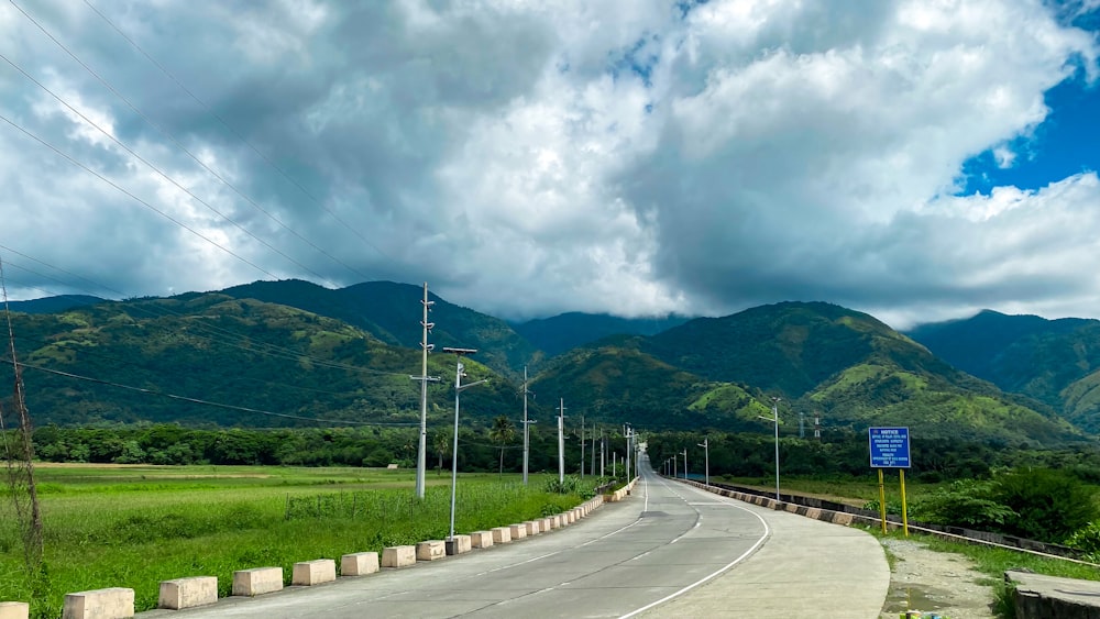 an empty road with mountains in the background