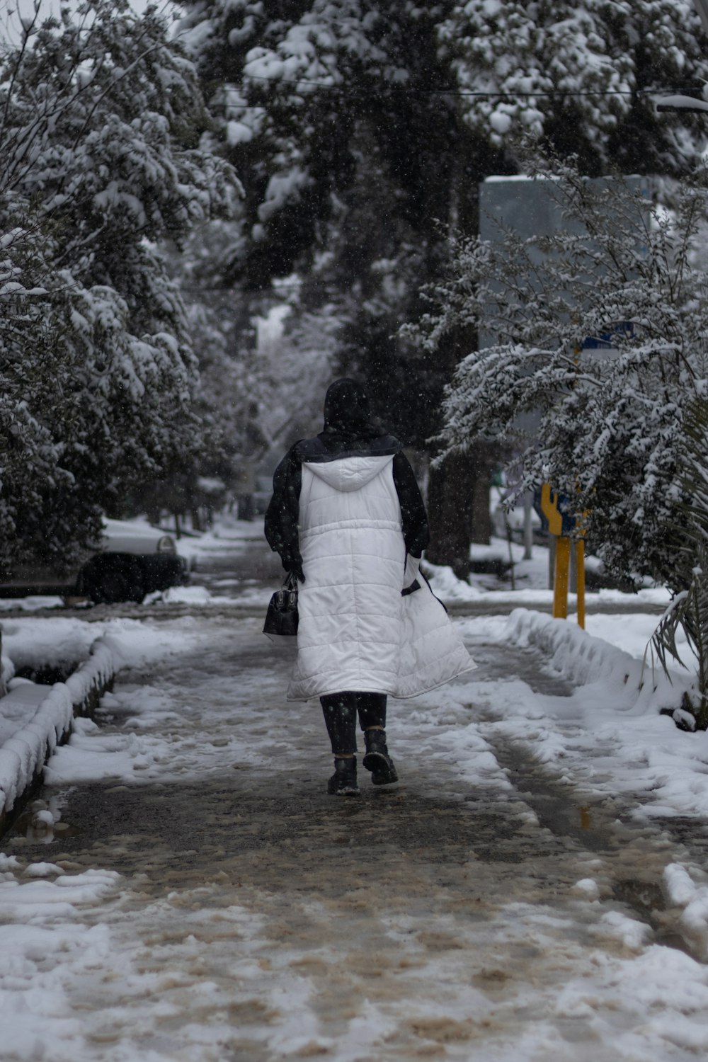 eine Person, die eine schneebedeckte Straße entlanggeht