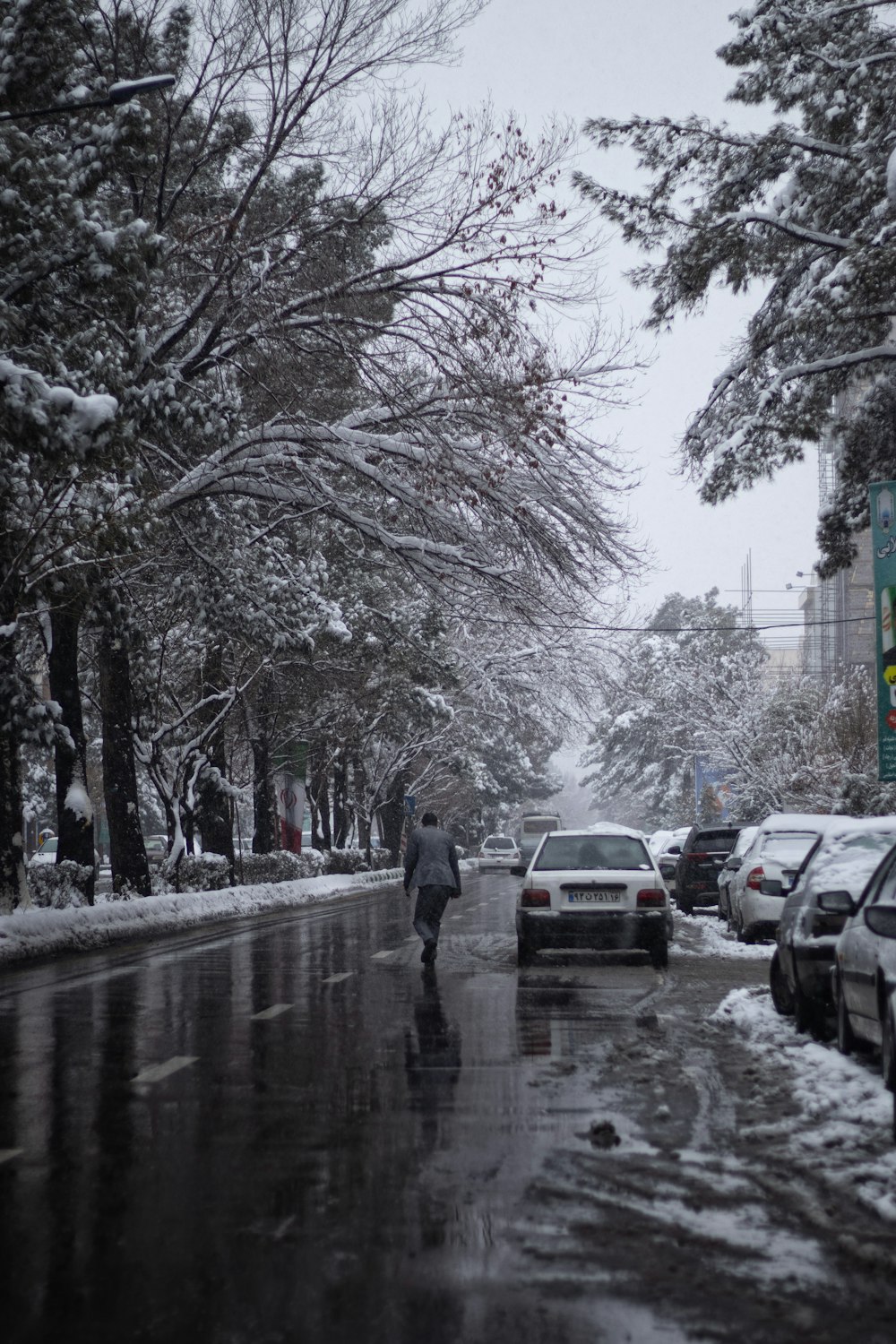 a person walking down a street in the snow