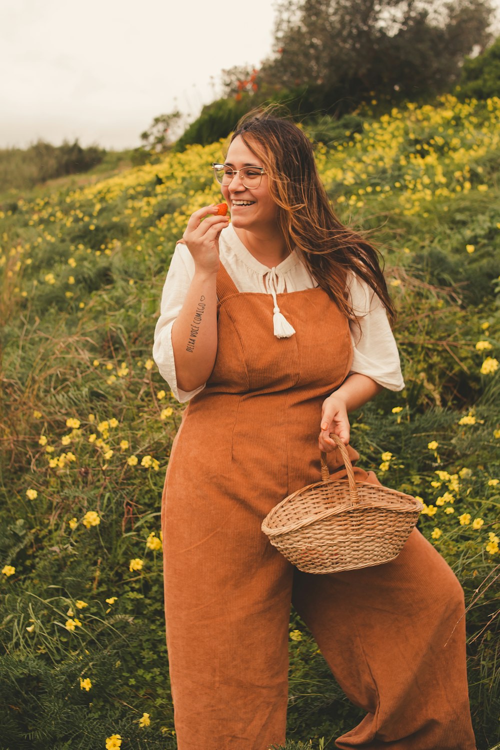 a woman standing in a field holding a basket