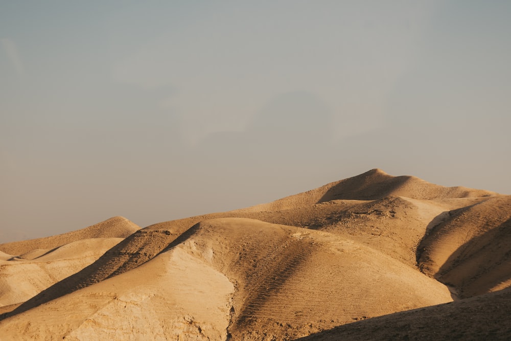 a hill covered in sand under a blue sky