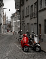 a row of scooters parked on a cobblestone street