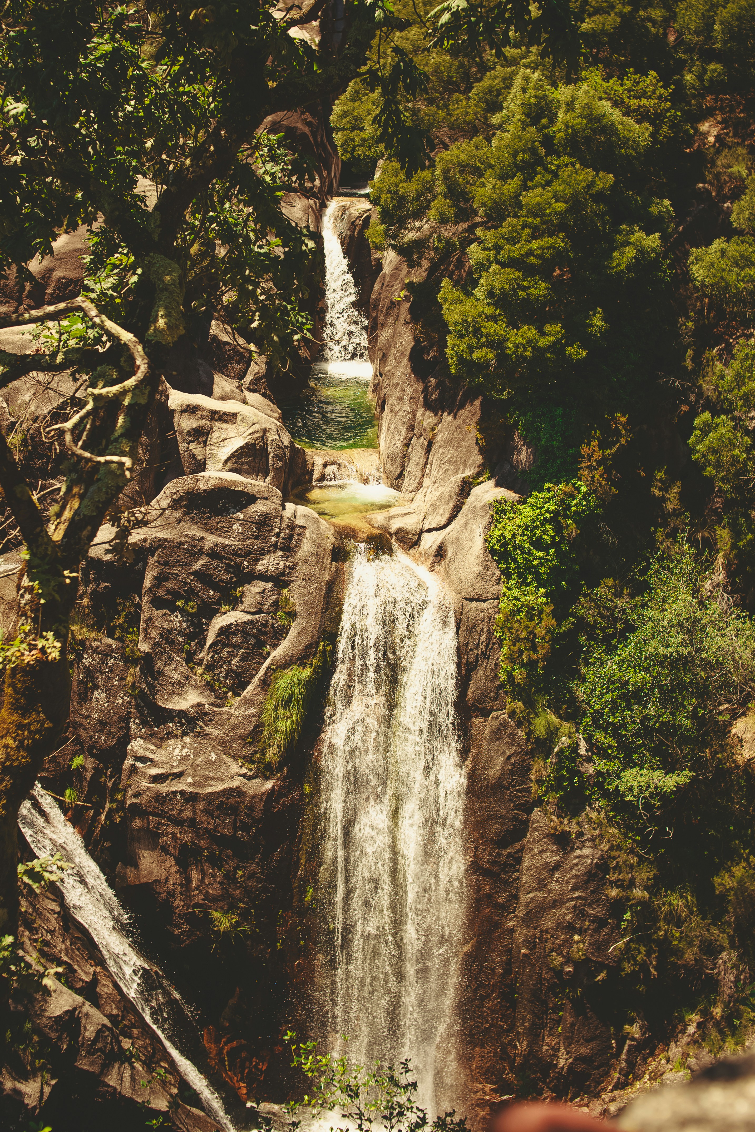 a large waterfall surrounded by trees and rocks